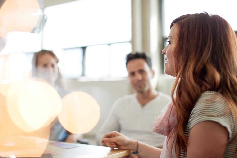 Unposed group of creative business people in an open concept office brainstorming their next project.